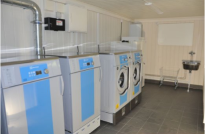 Multiple washers placed in a row in a laundry house module